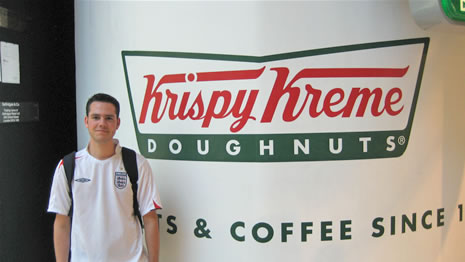 Phil Wylie posing outside Birmingham’s Krispy Kreme store